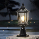 Victorian-inspired pedestal light glowing warmly on outdoor surface with classic hexagonal glass design