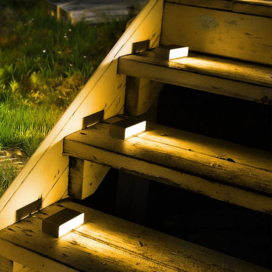 Warm LED step lights illuminating wooden outdoor stairs creating safe pathway navigation